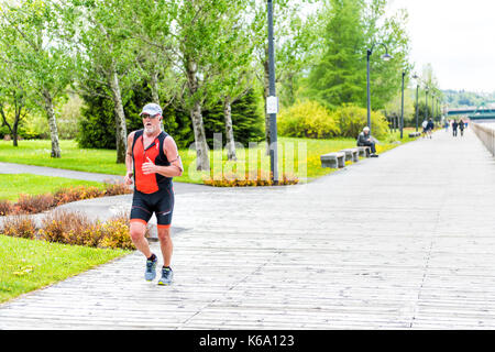 Saguenay, Canada - le 3 juin 2017 : promenade au centre-ville de terrasse parc de la ville de Québec au cours de l'été avec l'homme en marche, jogging par river Banque D'Images