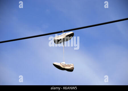 Une paire de baskets qui pendait au plafond électriques à câble le reste et d'être reconnaissants à Glen croe western highlands, Ecosse, Royaume-Uni. Banque D'Images