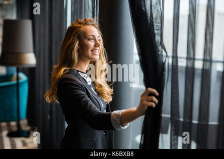 Pensive belle businesswoman looking through window Banque D'Images