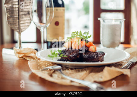 Côtes de porc grillé sur planche de bois, faible profondeur de champ Banque D'Images