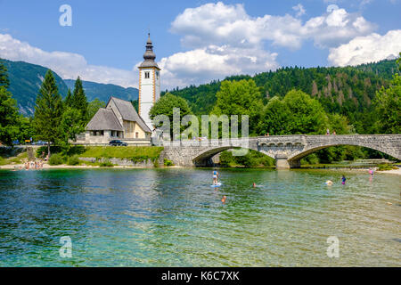 Église Saint-Jean-Baptiste et pont en pierre dans le village Ribčev Laz au lac Bohinj, Bohinjsko jezero dans le parc national Triglav Banque D'Images