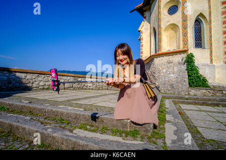 Une femme de touristes chinois prend un intérieur selfies le château, blejski grad, situé sur un éperon rocheux au-dessus du lac blejsko jezero, Bled Banque D'Images