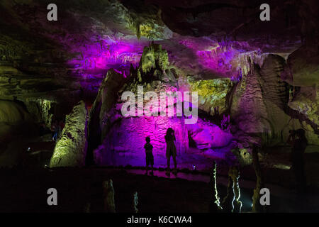 Un garçon et une fille à l'intérieur du système de grottes Prométhée, au nord-ouest de Koutaïssi en Géorgie.Les grottes sont éclairées avec des lumières colorées. Banque D'Images