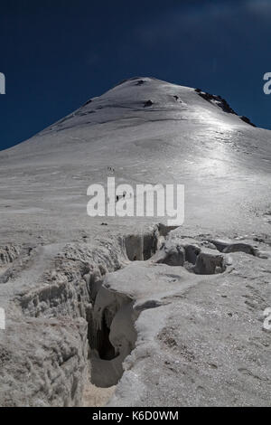 Jusqu'à passé une crevasse ouverte vers le sommet recouvert de glace du mont Kazbek (Kazbeg) en Géorgie, à 5047 mètres au-dessus du niveau de la mer. Banque D'Images