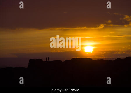 Silhouette de deux personnes debout sur la crête de montagne éloignés que l'établissement d'approches sun horizon dans le désert de Gobi dans la campagne de la Mongolie Banque D'Images