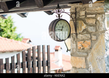 Vieille horloge suspendue sur le pilier à l'entrée du village à platamonas Banque D'Images