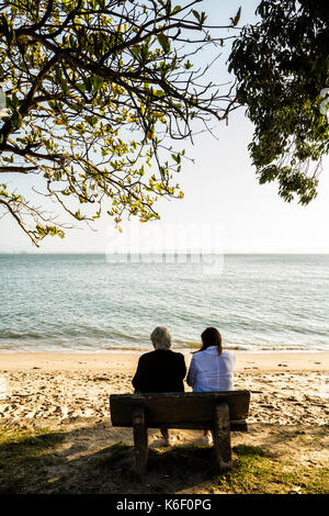 Mère et fille assises sur un banc à la plage de Santo Antonio de Lisboa. Florianopolis, Santa Catarina, Brésil. Banque D'Images