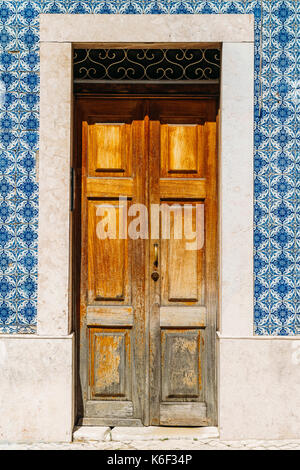 Vintage porte en bois avec des carreaux en marbre bleu mur à Lisbonne, Portugal Banque D'Images