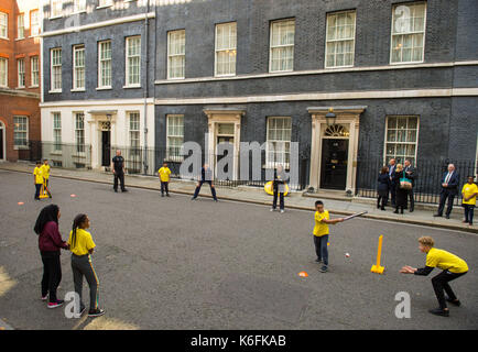 Le capitaine de l'angleterre stuart large (centre) se joint à un jeu de cricket sur la rue Downing Street, Londres, organisée par chance de briller street, qui cherche à mobiliser les jeunes âgés de 28-34 dans les régions de désavantage socio-économique dans la rue de cricket. Banque D'Images