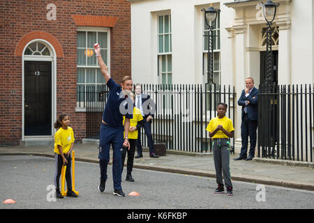 Le capitaine de l'angleterre stuart large (centre) se joint à un jeu de cricket sur la rue Downing Street, Londres, organisée par chance de briller street, qui cherche à mobiliser les jeunes âgés de 28-34 dans les régions de désavantage socio-économique dans la rue de cricket. Banque D'Images