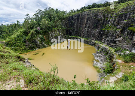 Homme marchant sur l'eau au-dessus de slackline dans Maripora Dibs, carrière, l'État de Sao Paulo, Brésil Banque D'Images