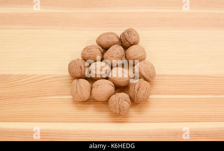 Les noix en coquilles sur un fond de bois de pin, du grain du bois Banque D'Images