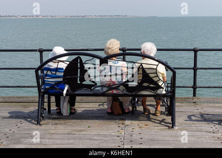 Trois femmes âgées assis sur un banc sur la jetée de Southend, Southend-on-Sea, Essex, Angleterre, Royaume-Uni, UK Banque D'Images