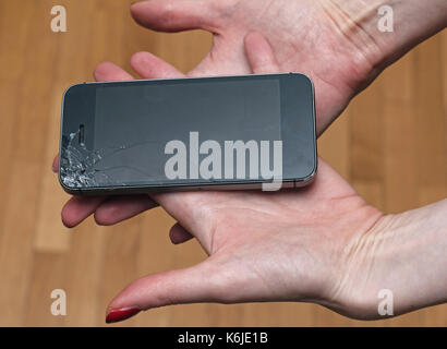 Les mains tenant l'écran brisé smart phone Banque D'Images