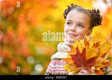 Portrait de pretty little girl resting in autumnal park Banque D'Images