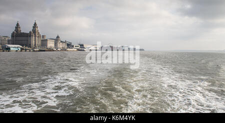 Un voyage sur la Mersey sur le célèbre ferry, avec l'emblématique des bâtiments de Liverpool's pier head derrière. Banque D'Images