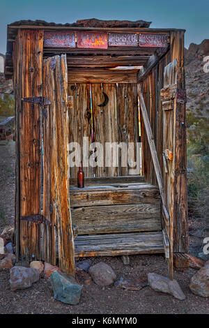 Western Outhouse - outhouse outhouse rustique en bois, une bouteille vide de l'intérieur et à l'ours ancien Nevada d'immatriculation sur l'extérieur. Banque D'Images