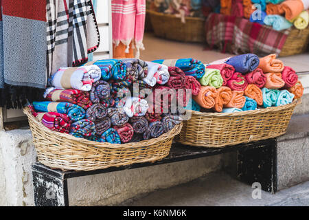 Rouleaux de serviettes multicolores dans un panier en osier sur une vitrine Banque D'Images