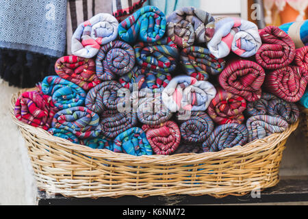 Rouleaux de serviettes multicolores dans un panier en osier sur une vitrine Banque D'Images