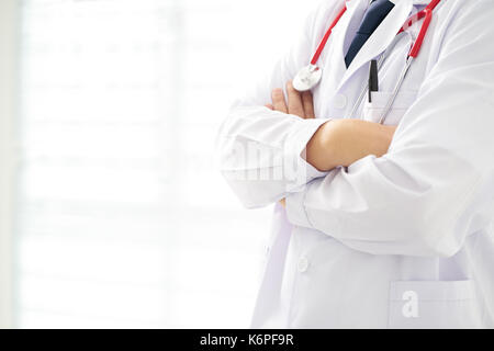 Unknow doctor posing with arms crossed dans le bureau, il porte un stéthoscope . Banque D'Images