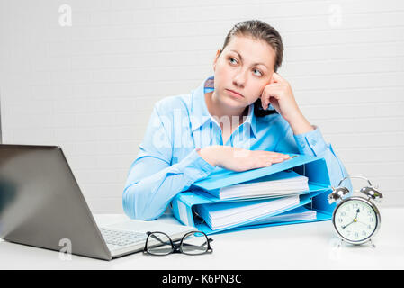 Un analyste financier réfléchie dans un bureau avec des documents Banque D'Images