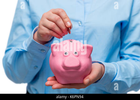 Photo conceptuelle - économiser de l'argent. close-up d'une main avec un monnayeur et un coin Banque D'Images