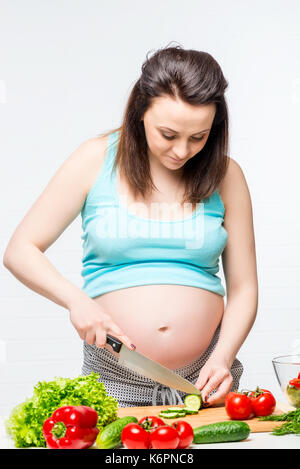 Young pregnant brunette la préparation des aliments sains Banque D'Images