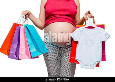 Des vêtements de son fils et d'autres achats dans les mains d'une femme enceinte, belly closeup Banque D'Images