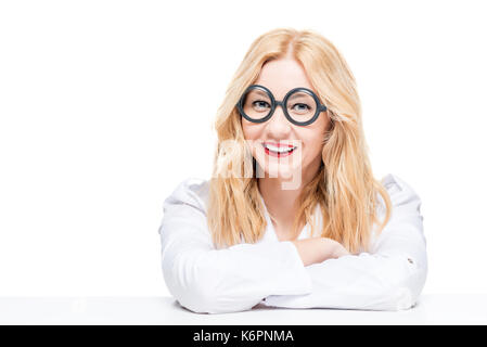 Blonde à lunettes dans une robe de médecin sur un fond blanc Banque D'Images