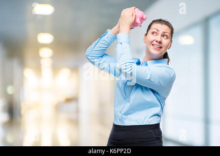 Portrait d'une fille avec un pink piggy bank dans le studio in office Banque D'Images