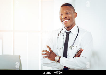 African smiling doctor with stethoscope with dans la chambre du médecin et à la recherche à l'appareil photo. Banque D'Images