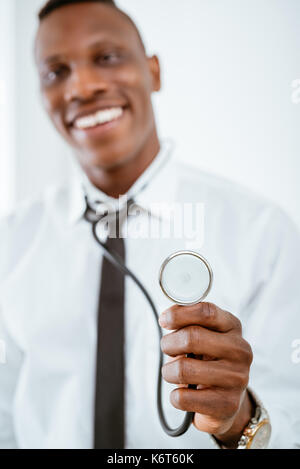 Close-up d'un stéthoscope dans la part d'un africain smiling doctor. focus sélectif. focus sur le premier plan, le stéthoscope. Banque D'Images