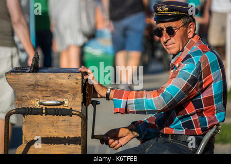 Sarbinowo, Pologne - août 2017 : busker rue avec un chapeau et des lunettes de soleil jouant sur une ancienne en bois instrument organette Banque D'Images