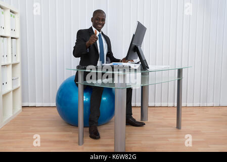 Portrait of happy young woman sitting on travail pilates ball Banque D'Images