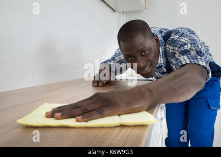 Photo de jeune homme africain plan de cuisine nettoyage Banque D'Images