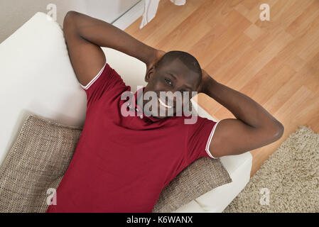 High angle view of African man relaxing on couch Banque D'Images