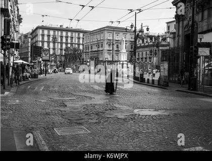 Vieille dame en noir Crossing Road à Naples Image en noir et blanc Banque D'Images