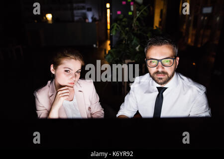 Les jeunes gens d'affaires de l'office de nuit travailler tard. Banque D'Images