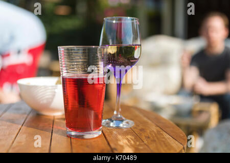 Les boissons d'été y compris jus de fruits, du vin et les chips sur une table de jardin en bois au Royaume-Uni Banque D'Images