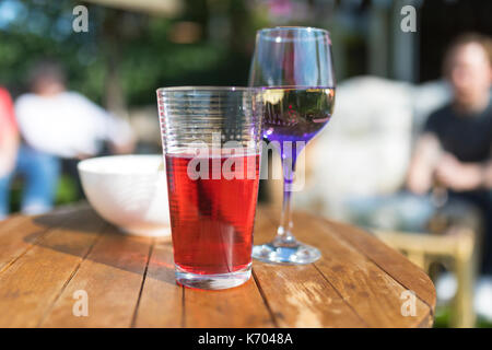 Les boissons d'été y compris jus de fruits, du vin et les chips sur une table de jardin en bois au Royaume-Uni Banque D'Images