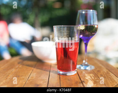 Les boissons d'été y compris jus de fruits, du vin et les chips sur une table de jardin en bois au Royaume-Uni Banque D'Images