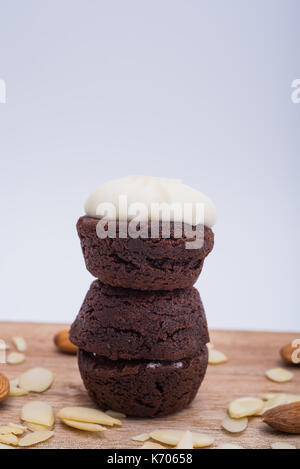 Pile de trois brownies au chocolat sur une planche à découper en bois Banque D'Images