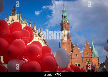 Ballons en rouge et blanc - les couleurs nationales de la Pologne avec l'Ancien hôtel de ville en arrière-plan, Wroclaw, Pologne Banque D'Images