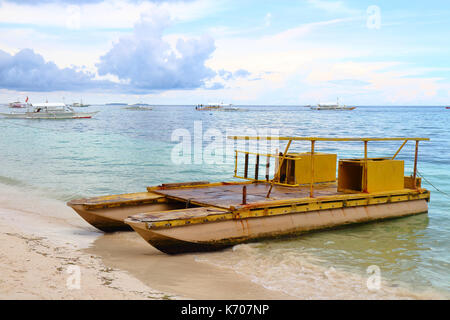 Un vieux rusty twin-hull boat utilisés pour le transport des touristes de l'île tropicale de Quezon aux Philippines. Banque D'Images