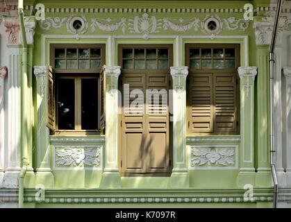 Extérieur de maison boutique traditionnel avec des fenêtres en bois brun, les majorquines et vert en façade historique de Singapour everton park Banque D'Images