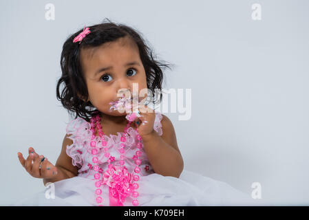 Toddler eating cake avec messy face close up portrait Banque D'Images