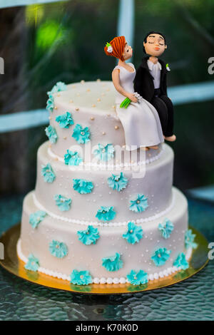 Figurines drôles suite à un mariage de luxe gâteau blanc. Banque D'Images