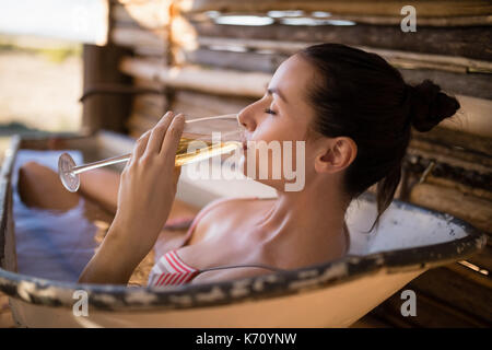 Woman having champagne dans une baignoire au cours de vacances à l'hôtel Banque D'Images