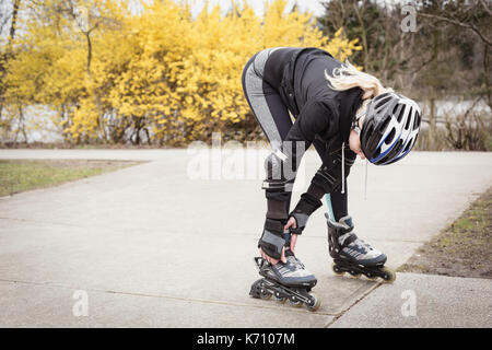 Femme portant des patins à roulettes dans le parc Banque D'Images