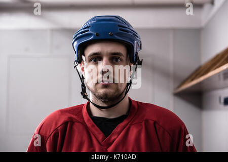 Portrait de joueur de hockey sur glace masculin de porter le casque, dressing Banque D'Images